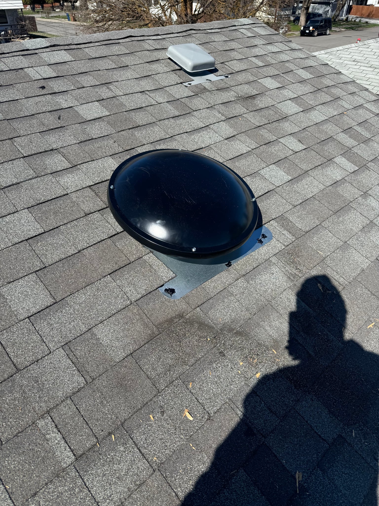 Roof vent installed among asphalt shingles